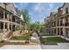 View of townhomes with a central walkway surrounded by greenery, trees and manicured lawns at 160 Chiswick Cir # 2, Alpharetta, GA 30009