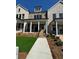 Inviting townhome featuring a stone facade, covered porch with white columns and a well-maintained lawn at 160 Chiswick Cir # 2, Alpharetta, GA 30009