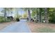 Exterior view of the home showcasing the long driveway, mature trees, and attached garage at 3226 Bruckner Blvd, Snellville, GA 30078