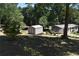 Backyard with shed and home surrounded by trees, offering a serene, private setting at 3400 Scott Dr, Austell, GA 30106