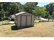 Tan and brown shed providing extra storage for lawn equipment in backyard at 3400 Scott Dr, Austell, GA 30106