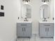 Grey vanity with double sinks, black hardware, and modern lighting at 5399 Emily Cir, Ellenwood, GA 30294