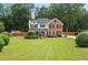 Charming two-story brick and siding home with a well-manicured front lawn and mature landscaping at 5399 Emily Cir, Ellenwood, GA 30294