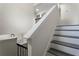 Modern staircase with sleek gray treads and a black railing leading to the upper level at 5399 Emily Cir, Ellenwood, GA 30294