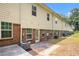 Back exterior view with patio, lawn, and air conditioning units; brick and siding at 876 Ivydale Ln # 63, Lawrenceville, GA 30045