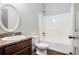 A well-lit bathroom with an oval mirror, a wood vanity, and a shower-tub combination at 876 Ivydale Ln # 63, Lawrenceville, GA 30045