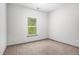 A neutral-toned bedroom featuring a window, carpet flooring, and painted walls at 876 Ivydale Ln # 63, Lawrenceville, GA 30045