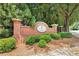 Community entrance sign featuring brick pillars, lush landscaping, and mature trees at 876 Ivydale Ln # 63, Lawrenceville, GA 30045