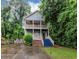 Two-story home featuring double balconies and a landscaped front yard surrounded by mature trees at 1103 Coleman Sw St, Atlanta, GA 30310