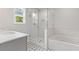 Modern bathroom featuring a glass-enclosed shower, a soaking tub, and stylish patterned tile flooring at 323 Hayden Circle Cir, Woodstock, GA 30189