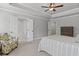 Serene main bedroom showcasing a tray ceiling, a cozy seating area, and a glimpse into the ensuite bathroom at 323 Hayden Circle Cir, Woodstock, GA 30189