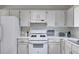 White kitchen with modern gas stove, white cabinets, and updated fixtures at 4255 Brandy Ann Dr, Acworth, GA 30101