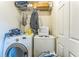 The laundry area has a washer, dryer, and wire shelf with clothing at 4945 Penscot Way, Stone Mountain, GA 30088