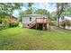 Expansive backyard featuring a deck, lush lawn, mature trees, and a stone foundation at 1098 Cascade Sw Cir, Atlanta, GA 30311