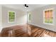 Bedroom with hardwood floors, ceiling fan, and sunlit windows overlooking greenery at 1098 Cascade Sw Cir, Atlanta, GA 30311