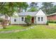 Charming single-story home with landscaped yard and a classic red front door at 1098 Cascade Sw Cir, Atlanta, GA 30311