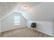 Cozy attic features textured ceiling and carpeted floors, perfect for a home office or storage at 118 Surge Stone Ln, Stockbridge, GA 30281