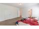 An empty bedroom with carpeted floors, two windows, and doors to other rooms at 118 Surge Stone Ln, Stockbridge, GA 30281