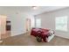 An empty bedroom with carpeted floors, two windows, and doors to other rooms at 118 Surge Stone Ln, Stockbridge, GA 30281