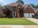 Charming two-story brick home with a well-manicured lawn and attached two-car garage at 118 Surge Stone Ln, Stockbridge, GA 30281