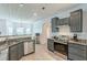 A kitchen featuring stainless steel appliances, granite countertops, and gray cabinetry at 118 Surge Stone Ln, Stockbridge, GA 30281