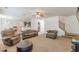 Inviting living room featuring neutral tones, a ceiling fan, and an open floor plan to the kitchen and dining area at 118 Surge Stone Ln, Stockbridge, GA 30281