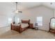 Spacious main bedroom features a large bed, vaulted ceiling, ceiling fan and lots of natural light at 118 Surge Stone Ln, Stockbridge, GA 30281