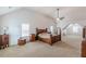 Large main bedroom with vaulted ceiling, carpet, a large bed, and windows for plenty of natural light at 118 Surge Stone Ln, Stockbridge, GA 30281