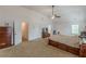 Spacious main bedroom with vaulted ceilings, carpet, ceiling fan, and large bed, with doors to other rooms at 118 Surge Stone Ln, Stockbridge, GA 30281