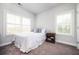 Bright bedroom with two windows, white bedding, bedside table, and carpeted floor at 2026 Forte Lane, Alpharetta, GA 30009