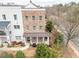 Aerial view of a three-story brick townhome with a covered front porch and manicured landscaping at 2026 Forte Lane, Alpharetta, GA 30009