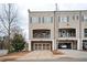 Inviting townhome showcases a two-car garage and a charming balcony, enhancing curb appeal and outdoor living at 2026 Forte Lane, Alpharetta, GA 30009