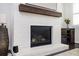 Close-up of the living room fireplace with a wood beam mantel and white painted brick at 2026 Forte Lane, Alpharetta, GA 30009
