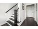 Hallway with dark wood floors and stairs featuring black and white risers at 2026 Forte Lane, Alpharetta, GA 30009
