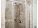 Shower featuring a shower head, bench, neutral-colored tiles, and clear glass at 2026 Forte Lane, Alpharetta, GA 30009
