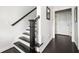 View of the staircase with dark wood treads and railings with white risers and walls, plus view of hallway and white door at 2026 Forte Lane, Alpharetta, GA 30009