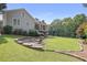 Beautifully landscaped backyard boasts a fire pit with stone seating, lush lawn, and mature trees at 515 Saint Barbaras Nw Ln, Marietta, GA 30064