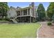 Expansive backyard features lush lawn, mature trees, stone patio, stairs, and outdoor living space under screened porch at 515 Saint Barbaras Nw Ln, Marietta, GA 30064