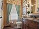 Charming bathroom features a decorative mirror, wood vanity, and wallpaper; cozy and well-lit at 515 Saint Barbaras Nw Ln, Marietta, GA 30064