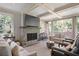 Cozy living room with stone fireplace, beamed ceiling, and large windows offering scenic views at 515 Saint Barbaras Nw Ln, Marietta, GA 30064