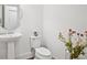 Simple powder room offers pedestal sink, modern fixtures, and floral accents at 6838 Prelude Dr, Atlanta, GA 30328