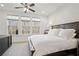 Bedroom features dark wood furniture, a ceiling fan, and three bright windows at 6838 Prelude Dr, Atlanta, GA 30328