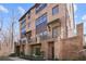 Brick townhome featuring dark windows, small patios, and well-maintained landscaping at 6838 Prelude Dr, Atlanta, GA 30328