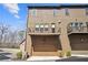 Tan townhome with garage, balcony, and manicured front yard at 6838 Prelude Dr, Atlanta, GA 30328