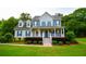 Traditional two-story home featuring blue shutters, a covered front porch, and lush green lawn at 855 Hood Rd, Fayetteville, GA 30214