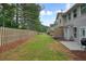 Backyard featuring green grass, a patio, and a row of townhomes with neutral colored exteriors and a wooden fence at 411 Mountain View Ln, Woodstock, GA 30188