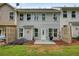 A backyard featuring green grass, a patio, and a row of townhomes with neutral colored exteriors at 411 Mountain View Ln, Woodstock, GA 30188