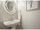 This powder room features a pedestal sink, round mirror and classic paint color at 411 Mountain View Ln, Woodstock, GA 30188