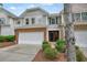 Inviting townhome with brick accents, lush landscaping, and an attached one-car garage at 411 Mountain View Ln, Woodstock, GA 30188