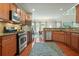 An open kitchen features wood cabinets, stainless appliances, granite countertops, and hardwood floors at 411 Mountain View Ln, Woodstock, GA 30188